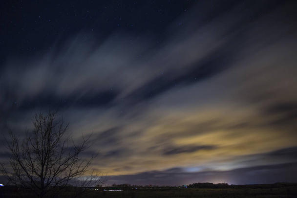 Güzel gece gökyüzünde yıldızlar ve bulutların üstünde uzun pozlama ile - Fotoğraf, Görsel