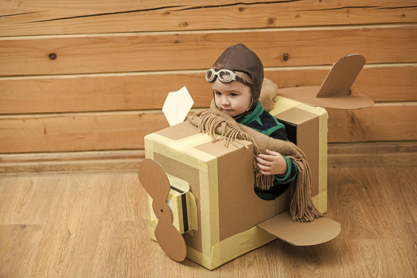 Little cute boy playing with a cardboard airplane - 写真・画像