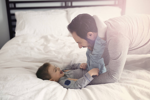 Baba ve oğul yatakta, yatakta mutlu saat - Fotoğraf, Görsel