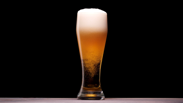 Üvegbe öntött világos sör. Buborékkal és habbal. - Felvétel, videó