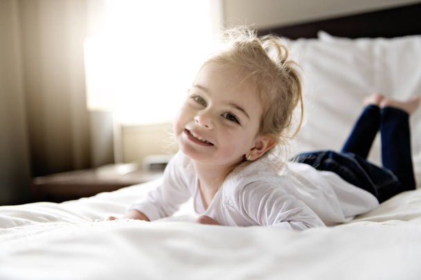 young daughter two years old relaxing in bed, positive feelings - Photo, image