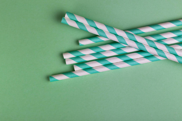 Colorful paper straws on bright green background. Event and party supplies. Earth pollution concept. Copy space - Photo, Image