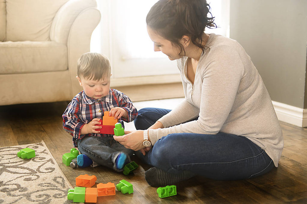 Mother and child boy building from toy blocks at home - Photo, image
