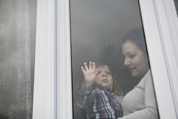 mother and toddler son looking out window outside - Zdjęcie, obraz