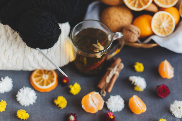 Mandarin, virágok, mézeskalács, citrus sraw kosár, meleg pulóver, csésze tea és narancs szeletek. Karácsonyi téli háttér, tapéta, üdvözlőlap. Felülnézet, lapos feküdt, a háttér, a másolás terek - Fotó, kép