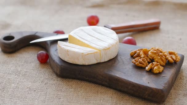 Bílá plíseň sýr otočit na dřevěném prkénku - Záběry, video