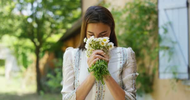 video of caucasian woman smelling white daisies flowers bouquet  - Video