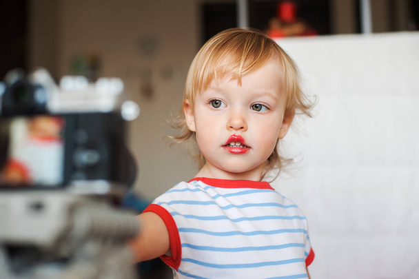 Pequeña niña rubia divertida hacer los labios con lápiz labial rojo de mamá. Aprender a ser mujer. Concepto de infancia feliz
.  - Foto, Imagen