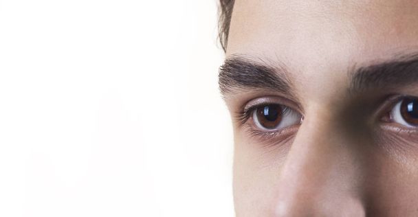 The eyes of the caucasian young man, a teenager. Close-up. Isolated on white background - Φωτογραφία, εικόνα