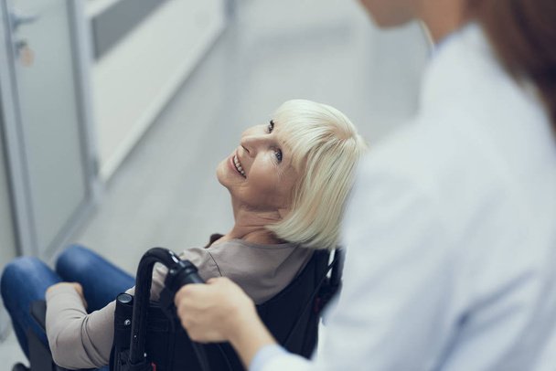 Smiling aged lady on pushchair is enjoying medic assistance - Fotoğraf, Görsel