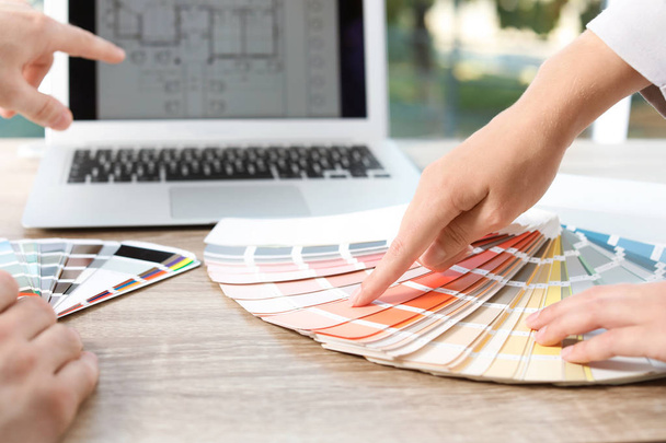 Команда дизайнеров, работающих с цветовой палитрой за столом офиса, крупным планом
 - Фото, изображение