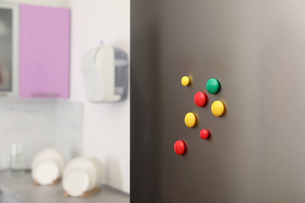 Muchos imanes de colores en la puerta del refrigerador en interiores
 - Foto, imagen