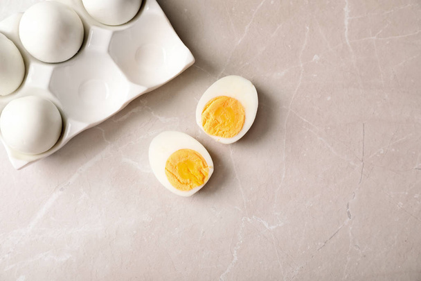 Flat lay composition with boiled eggs and space for text on gray background - Valokuva, kuva