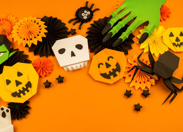Orange background with collection of Halloween objects overhead view. Skull, pumpkin, ghost, monster, green hand, spider, bat, witch, feared party decor. Handwork. - Foto, imagen