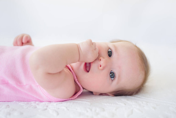 Очаровательная девочка 4 месяца, отдыхающая на кровати только что проснулась
 - Фото, изображение