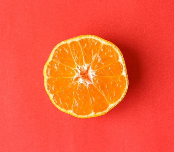 Orangenschale auf rotem Hintergrund - Foto, Bild