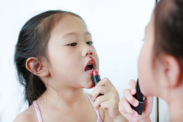 Closeup little Asian child girl playing with mothers makeup. - Foto, Imagem
