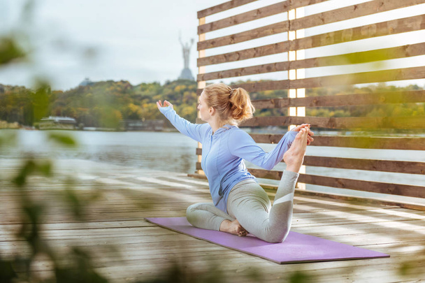 Woman stretching her muscles after doing morning exercises - Valokuva, kuva