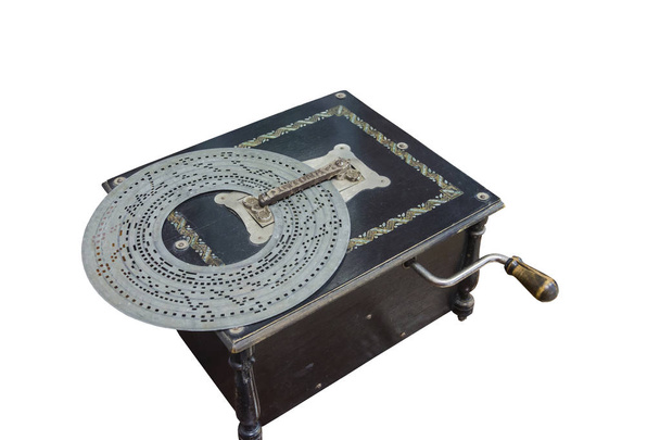 Old-time music box in a black wooden box with perforated metal disc on a white background. - Foto, afbeelding