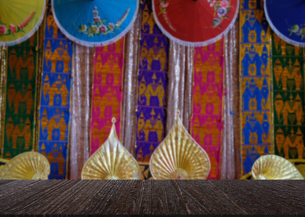 renkli geleneksel kumaş, kağıt şemsiye ve görüntüleme ürün için ahşap masa ile Tayland altın fan - Fotoğraf, Görsel