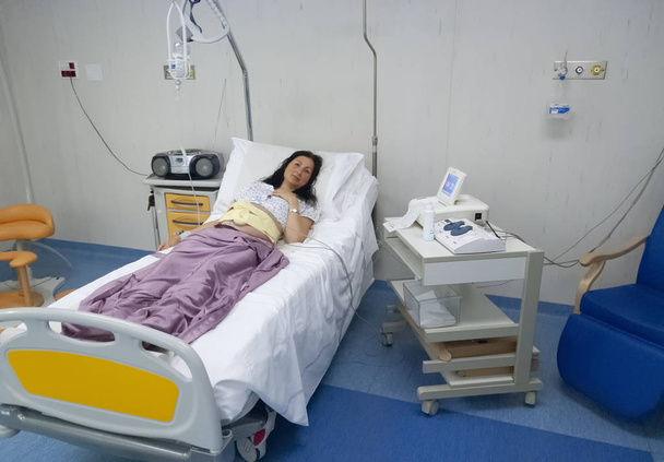 Doğumhane hastane renkli yatakta. Gebelik ve sağlık kavramı. Kadının EKG emek önce yapması. - Fotoğraf, Görsel
