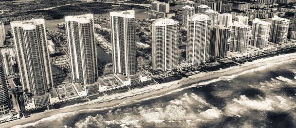 Aerial view of North Miami Beach skyscrapers with sun and clouds. - Photo, Image