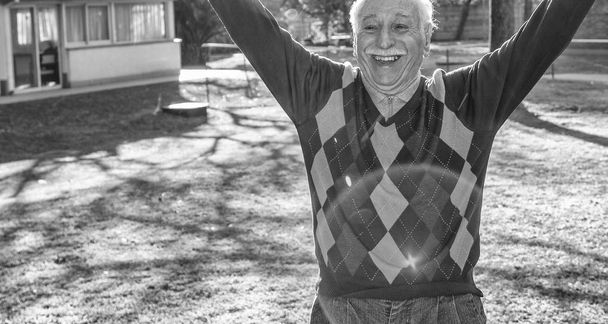 Ευτυχισμένος ηλικιωμένους man αυξάνοντας τα χέρια στον κήπο. - Φωτογραφία, εικόνα
