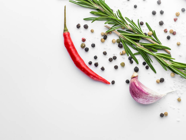 Red hot chilli pepper, garlic and rosemary with sea salt and colored pepper on white background - Foto, Bild