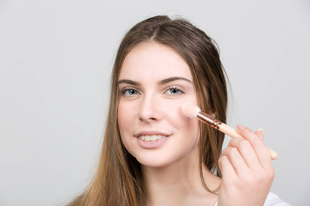 θηλυκό έφηβο εφαρμογή ρουζ για της make up - Φωτογραφία, εικόνα