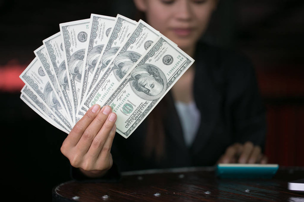 Business woman displaying a spread of cash over,  spending money or profit from business operations concept - Photo, Image