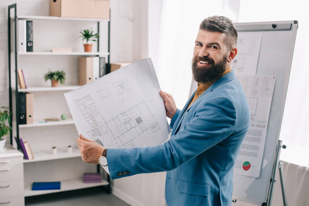 Handsome architect standing in modern office with blueprint  - Photo, Image