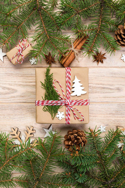 Christmas background with fir tree and gift box on wooden table. Top view with copy space for your design. - Foto, Bild