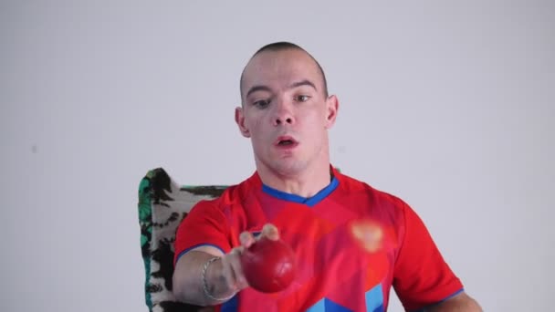 A fogyatékossággal élő ember egy tolószékben. Dobott a piros kis labdát a levegőben. Boccia. Portré - Felvétel, videó