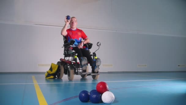 Un hombre discapacitado en silla de ruedas. Lanzar una bolita azul. Boccia
. - Metraje, vídeo