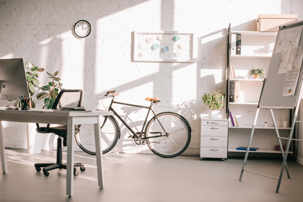 modern office design with flip chart, bicycle and computer desk - Fotoğraf, Görsel