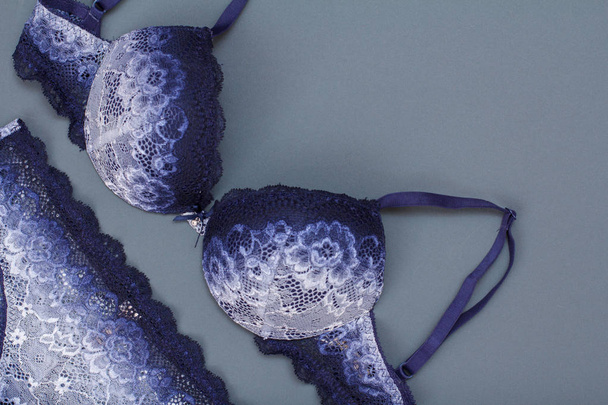Beautiful, blue lace bra and panties on gray background. Women sexy underwear set. Romantic lingerie for temptation. - Фото, зображення