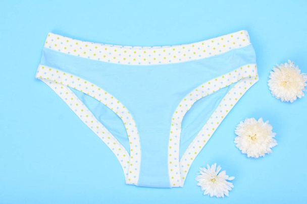 Beautiful panties with buds of flowers on blue background. Women underwear set. Top view. - Photo, Image