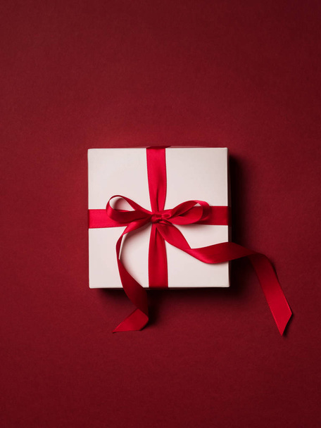 Felülnézet ajándék doboz-val piros szalag felett piros háttér - Fotó, kép