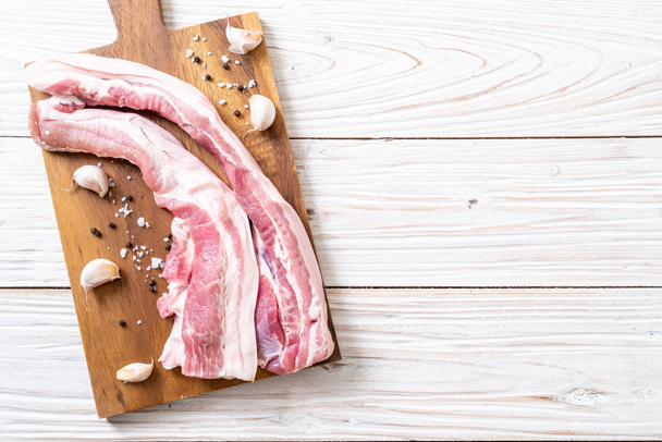 fresh raw streaky pork on wood board with ingredient - Fotó, kép