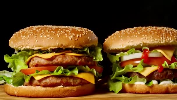 Dvě plavidla hovězí hamburgery na dřevěný stůl izolované na pozadí tmavé odstíny šedi. - Záběry, video