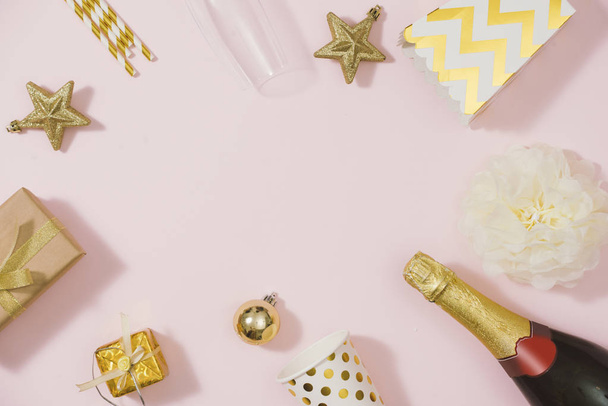 подарункова коробка, пляшка шампанського та святкові прикраси на рожевому фоні
 - Фото, зображення