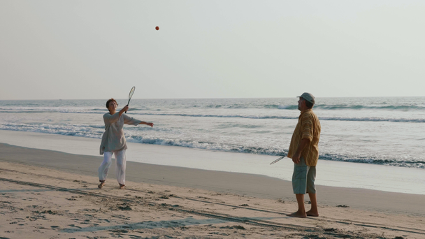 ビーチで太極拳気球ボールを弾いてアクティブ シニア カップル. - 映像、動画