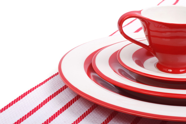 Table setting. Red plates and cups for tea on striped napkin - Φωτογραφία, εικόνα