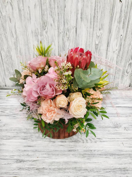 Author's floral arrangement with rare, tropical flowers and plants on a white vintage background. Florist at a flower shop - Photo, Image