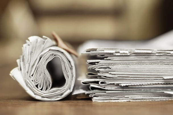 Jornais no escritório. Papéis enrolados e dobrados com notícias sobre mesa de madeira. Tabloide revistas empilhadas em pilha, vista lateral
   - Foto, Imagem