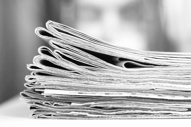 Sok hajtogatott újságok halmozott halom fából készült asztal, oldalnézetből   - Fotó, kép