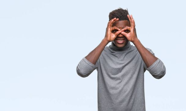 Young african american man over isolated background doing ok gesture like binoculars sticking tongue out, eyes looking through fingers. Crazy expression. - Zdjęcie, obraz