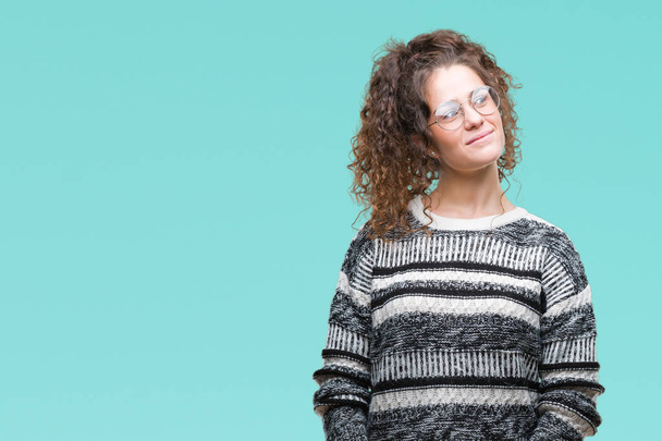 Beautiful brunette curly hair young girl wearing glasses over isolated background smiling looking side and staring away thinking. - Photo, Image