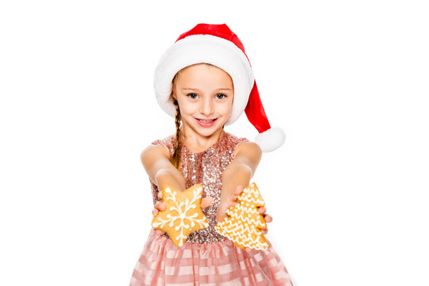 adorable little child in santa hat with ginger cookies looking at camera isolated on white - Fotoğraf, Görsel