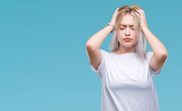 Young blonde woman over isolated background suffering from headache desperate and stressed because pain and migraine. Hands on head. - Photo, Image